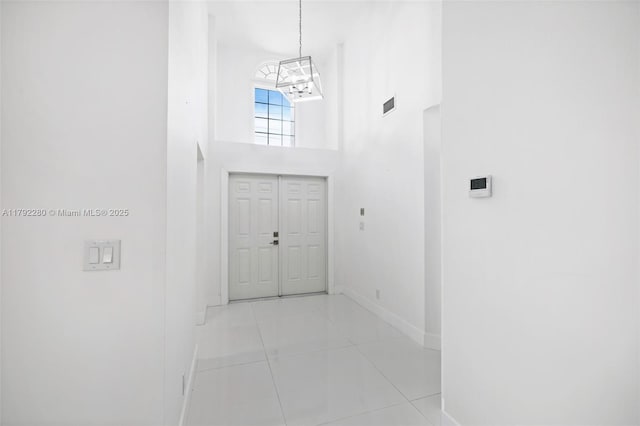 11069 Rios Rd, Boca Raton, FL 33498 - tiled foyer featuring a high ceiling, an inviting chandelier, baseboards, and visible vents
