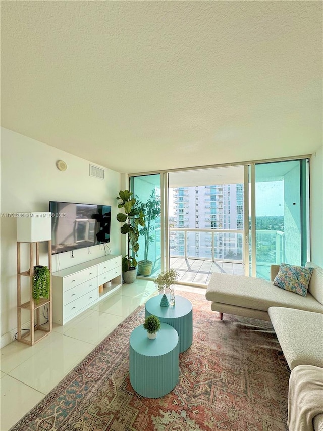 tiled living area featuring floor to ceiling windows, visible vents, and a textured ceiling
