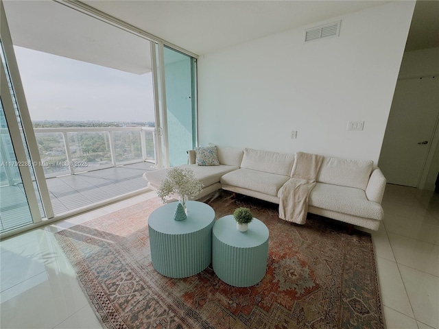 tiled living room with visible vents and expansive windows