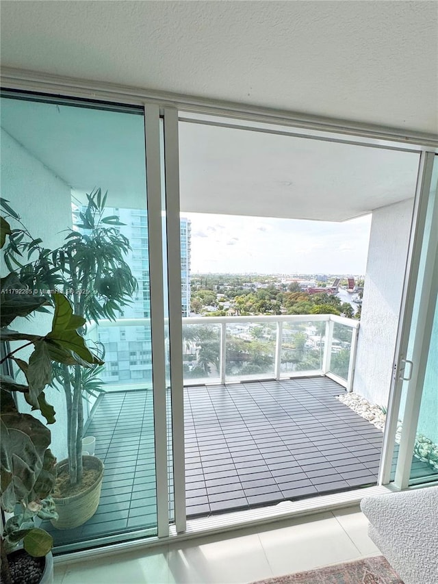 doorway to outside featuring tile patterned flooring, a wall of windows, and a textured ceiling