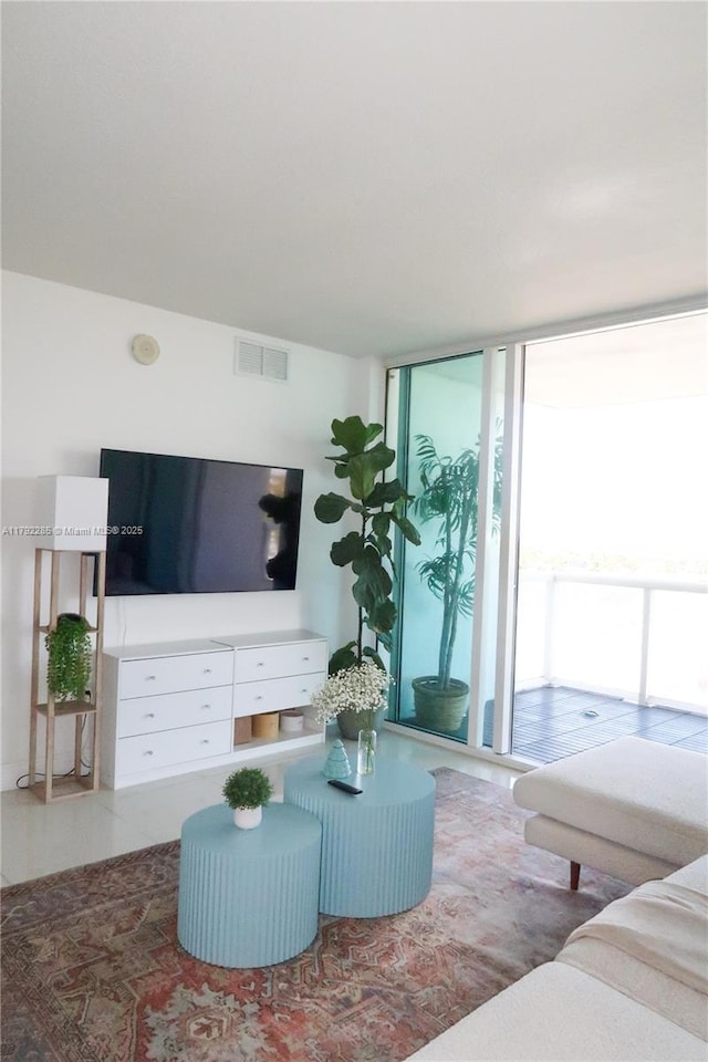living area featuring visible vents and floor to ceiling windows