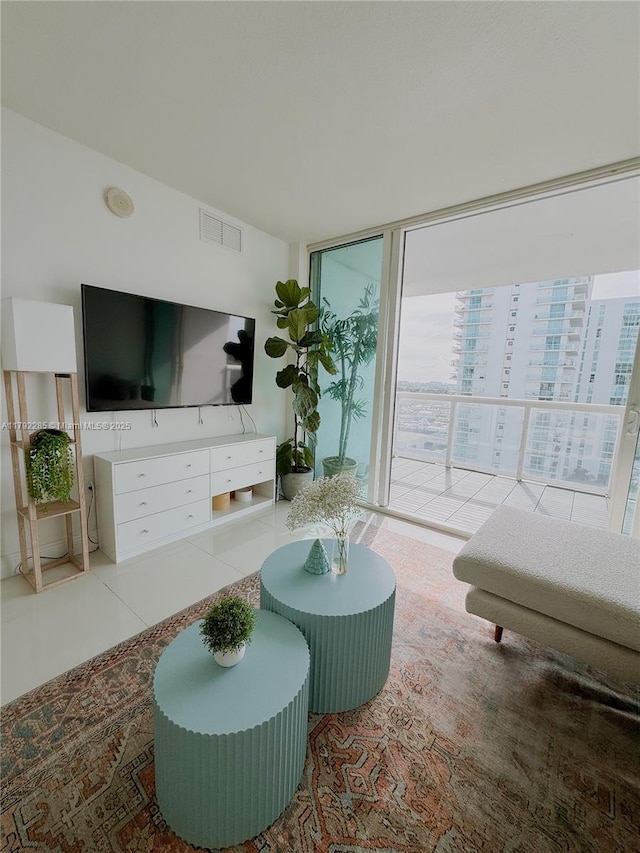 tiled living area with visible vents and floor to ceiling windows