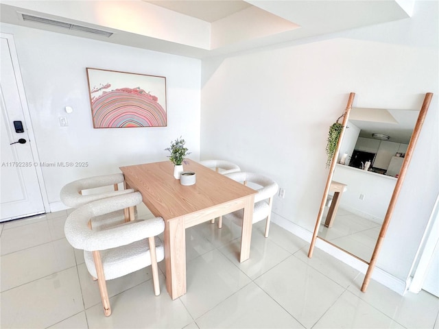 dining space featuring light tile patterned floors, visible vents, and baseboards