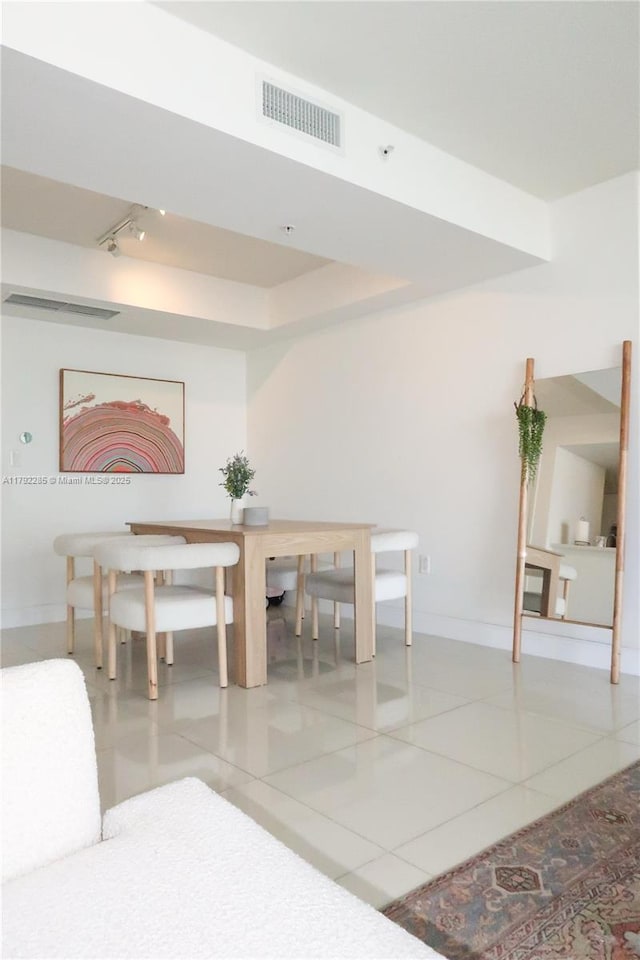 dining area featuring track lighting, visible vents, tile patterned floors, and baseboards