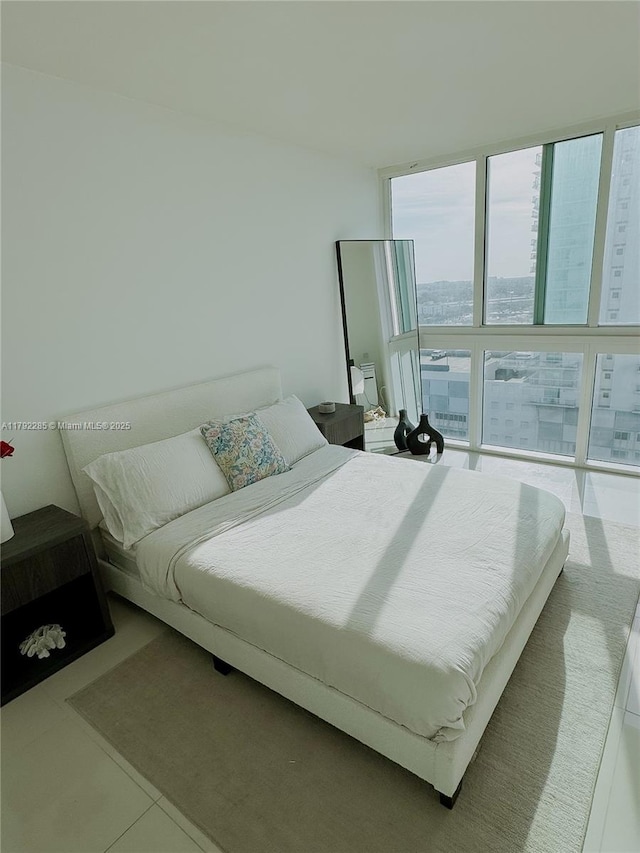 tiled bedroom featuring a wall of windows