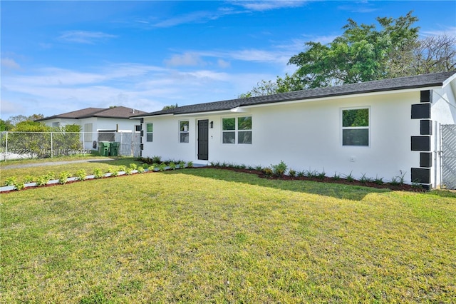 ranch-style house with a front lawn, stucco siding, and fence