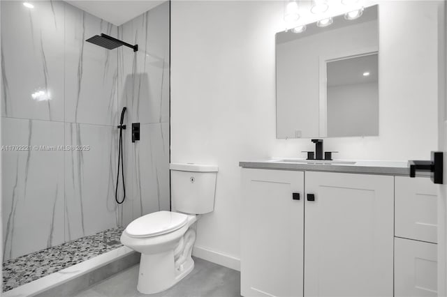 full bathroom featuring vanity, toilet, baseboards, and a marble finish shower