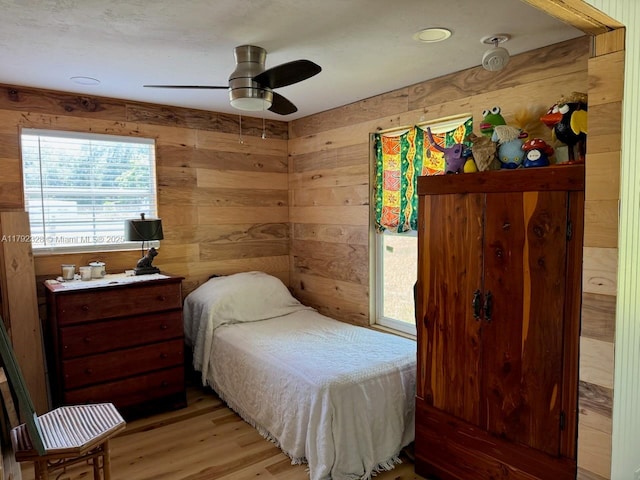 3725 SW 162nd St, Gainesville, FL 32618 - bedroom featuring wooden walls, light wood-type flooring, access to exterior, and a ceiling fan