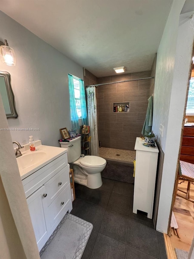 3725 SW 162nd St, Gainesville, FL 32618 - bathroom featuring tiled shower, vanity, toilet, and tile patterned flooring