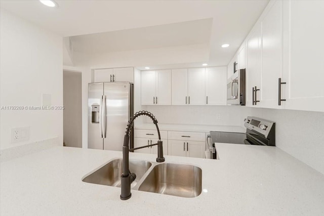 kitchen featuring recessed lighting, stainless steel appliances, light countertops, and a sink