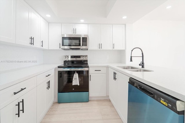 kitchen with stainless steel appliances, recessed lighting, white cabinets, and a sink