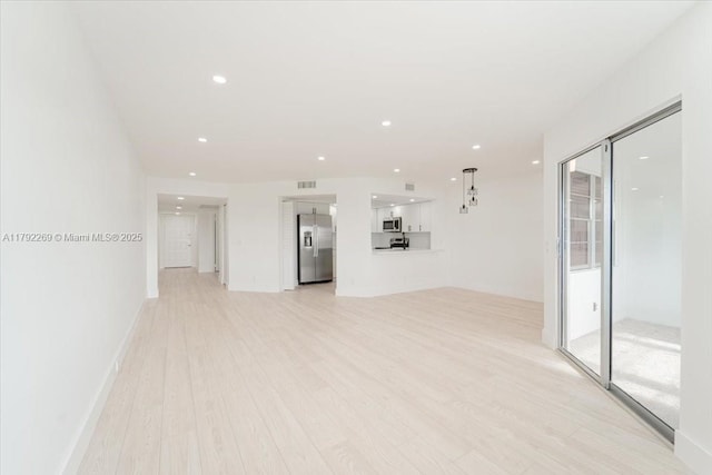 unfurnished living room with visible vents, light wood-type flooring, and recessed lighting