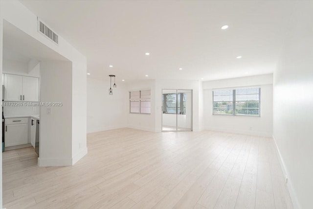unfurnished living room with visible vents, recessed lighting, light wood finished floors, and baseboards