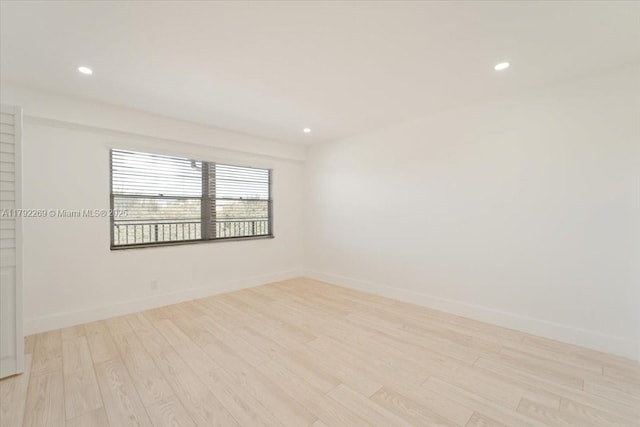 empty room with recessed lighting, light wood-style flooring, and baseboards
