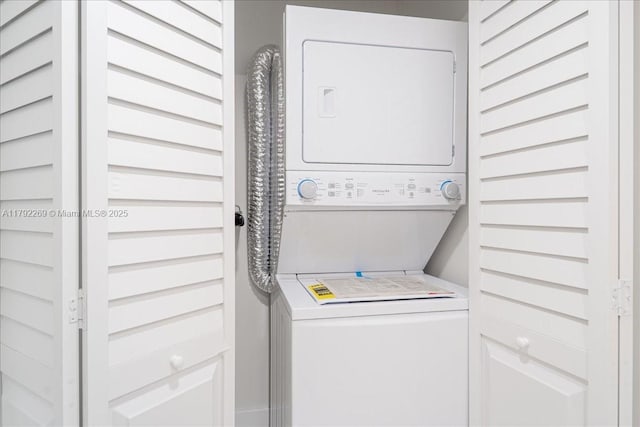 washroom with stacked washer / drying machine and laundry area