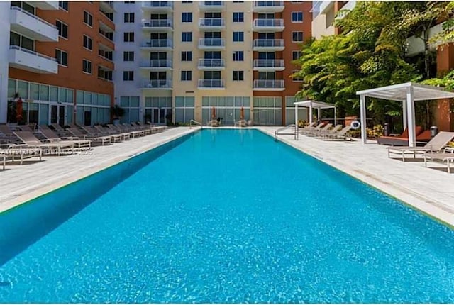 pool featuring fence and a patio area