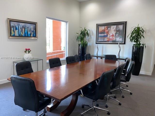 carpeted office featuring baseboards