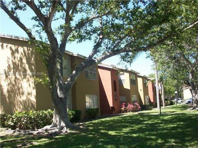 exterior space with stucco siding and a yard