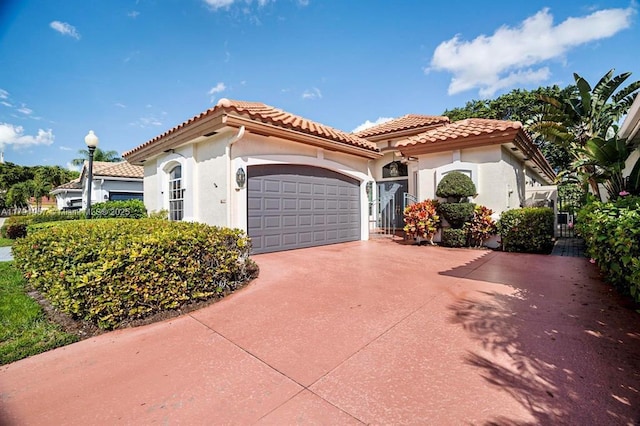 6375 NW 24th St, Boca Raton, FL 33434 - mediterranean / spanish house with a tile roof, driveway, an attached garage, and stucco siding