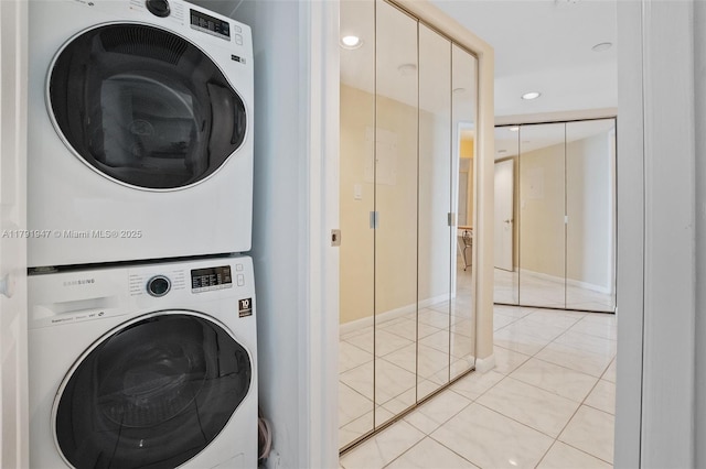 clothes washing area featuring recessed lighting, laundry area, stacked washer / dryer, light tile patterned floors, and baseboards