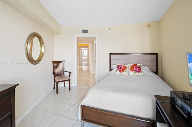 bedroom featuring light tile patterned floors, visible vents, and baseboards