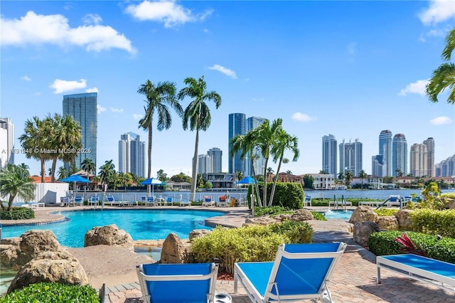 community pool with a patio and a city view