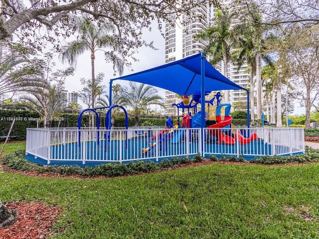community jungle gym featuring fence and a yard
