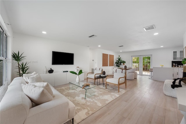 living room with visible vents, recessed lighting, and light wood finished floors