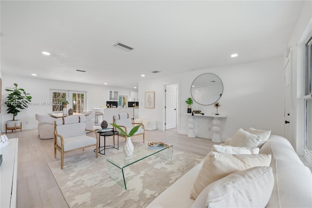 living area with recessed lighting, visible vents, and light wood-type flooring