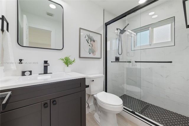 bathroom featuring visible vents, a marble finish shower, toilet, and vanity