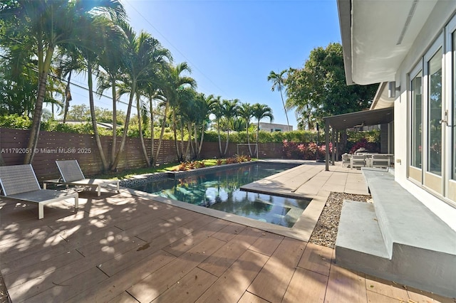view of pool with a fenced in pool, a wooden deck, and a fenced backyard