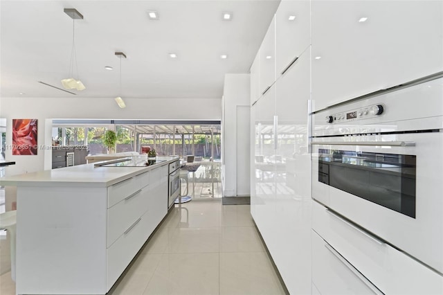 kitchen with modern cabinets, white cabinets, white oven, and light countertops