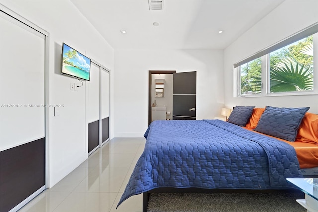 bedroom with tile patterned floors, visible vents, ensuite bath, and recessed lighting