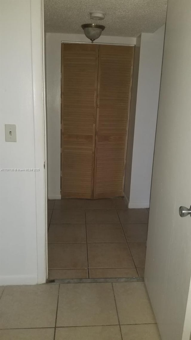 8240 SW 210th St Unit 313, Cutler Bay, FL 33189 - corridor with light tile patterned floors, baseboards, and a textured ceiling