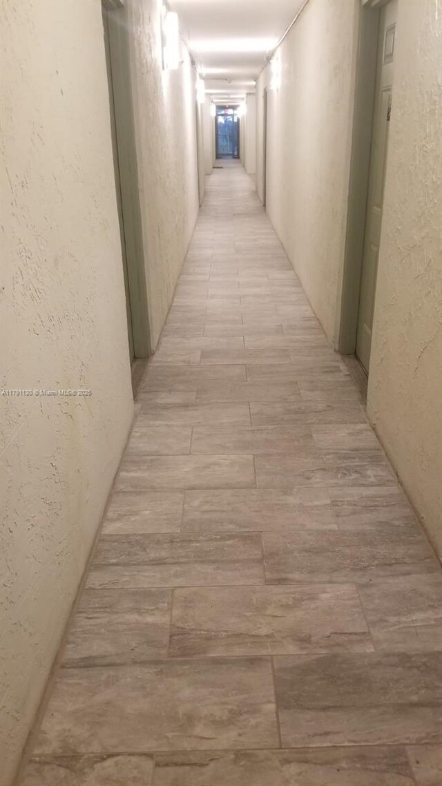 8240 SW 210th St Unit 313, Cutler Bay, FL 33189 - hallway featuring a textured wall and light wood-style flooring