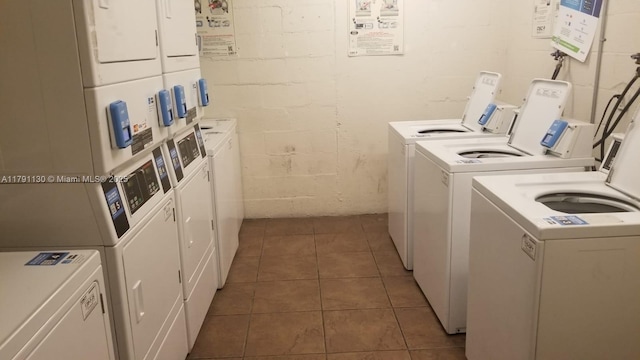 8240 SW 210th St Unit 313, Cutler Bay, FL 33189 - shared laundry room featuring stacked washer and clothes dryer, washing machine and dryer, concrete block wall, and tile patterned flooring