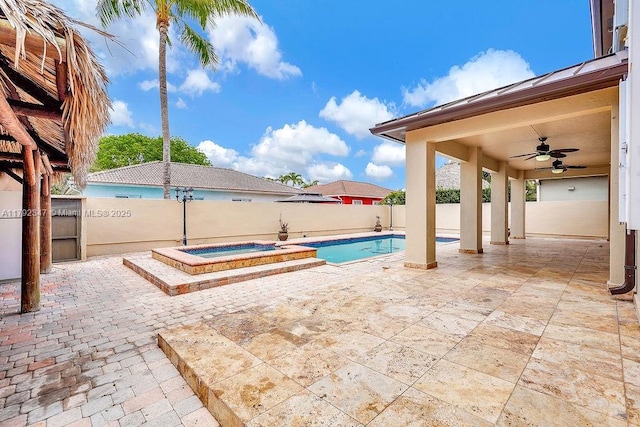 view of swimming pool with a fenced backyard, a ceiling fan, a pool with connected hot tub, and a patio area