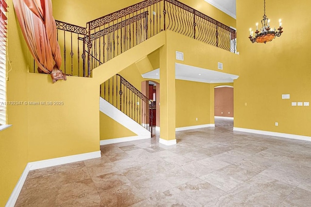 interior space featuring ornamental molding, arched walkways, and baseboards