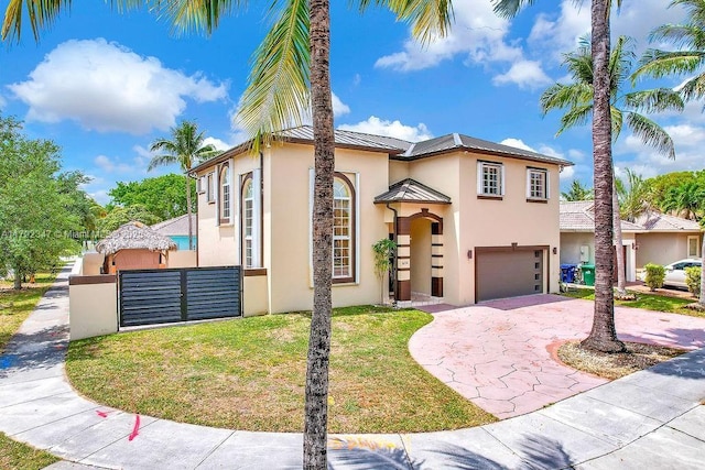 mediterranean / spanish-style home with stucco siding, a standing seam roof, metal roof, driveway, and an attached garage