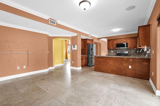 kitchen with brown cabinets, stainless steel appliances, decorative backsplash, visible vents, and arched walkways