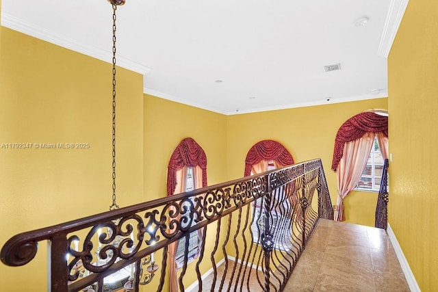 hallway featuring visible vents, crown molding, and baseboards