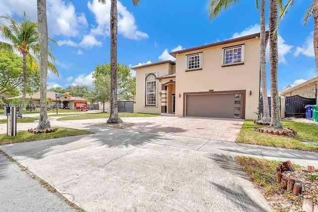 mediterranean / spanish-style house with fence, stucco siding, concrete driveway, and an attached garage