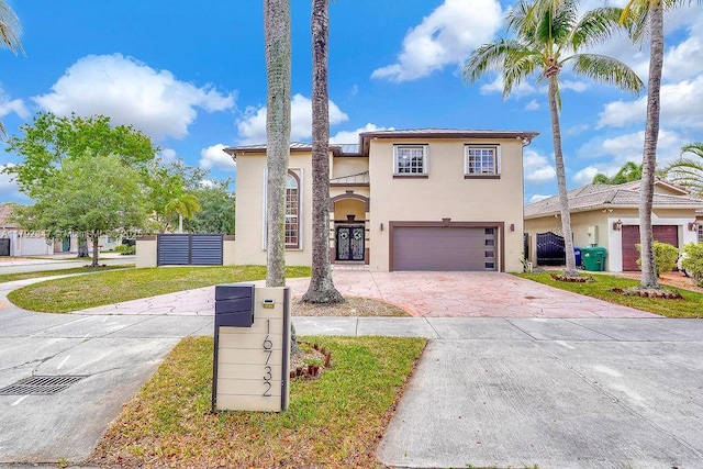 traditional home featuring stucco siding, fence, driveway, and a garage