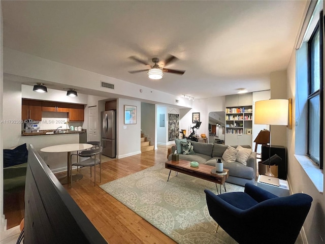 888 S Douglas Rd Unit 119, Coral Gables, FL 33134 - living room featuring light wood-type flooring, stairs, visible vents, a ceiling fan, and baseboards