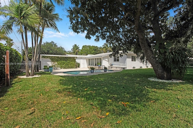 view of yard with an outdoor pool, a patio area, and fence