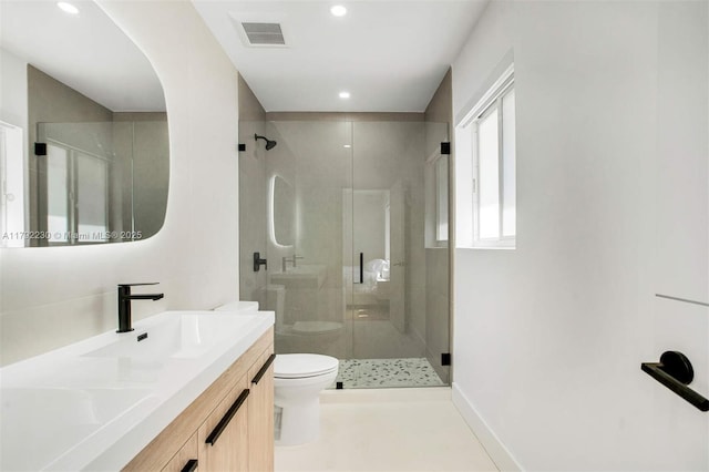 bathroom with double vanity, visible vents, toilet, and a shower stall