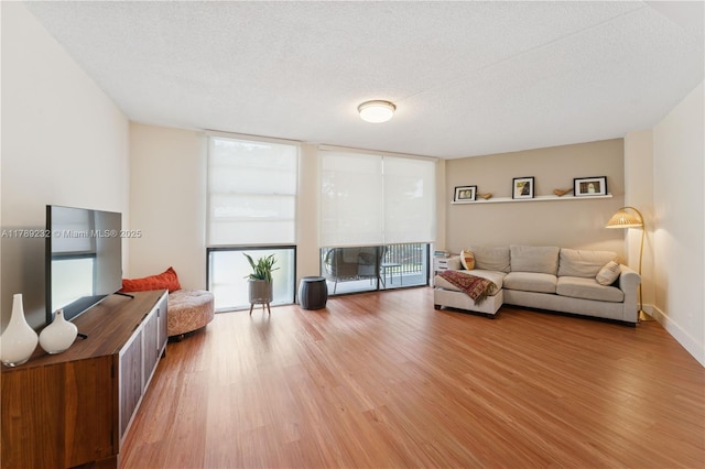 living area featuring expansive windows, a textured ceiling, and wood finished floors