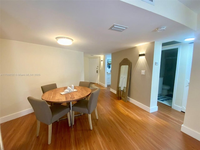 dining room with light wood-type flooring and baseboards