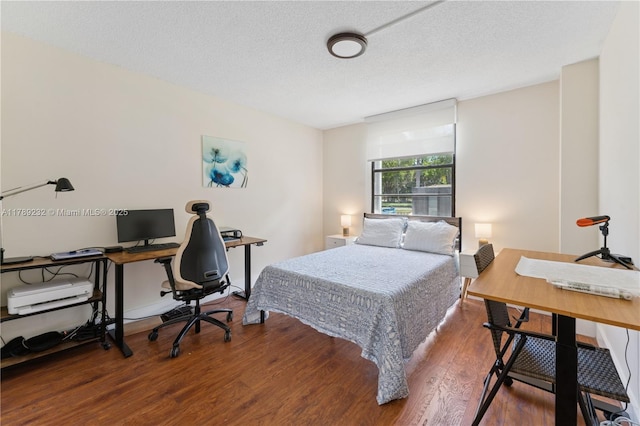bedroom with a textured ceiling and wood finished floors