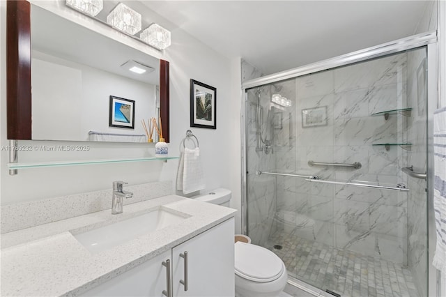 full bathroom featuring toilet, a marble finish shower, and vanity
